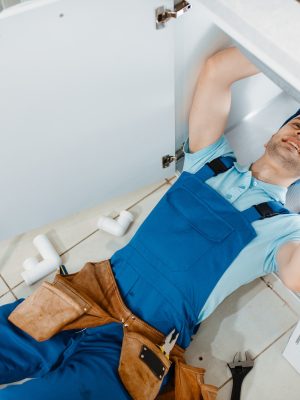 plumber-in-uniform-installing-drain-pipe-top-view.jpg